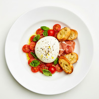 Bowl of marinated heirloom tomatoes, cucumber, stracciatella, mint & basil